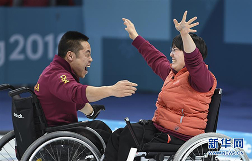 这是2018年3月17日，中国轮椅冰壶队队员王蒙（右）和刘微在夺冠后庆祝。在2018平昌冬残奥会轮椅冰壶决赛中，中国队以6比5战胜挪威队获得金牌，实现了中国代表团冬残奥会金牌零的突破。新华社记者夏一方摄