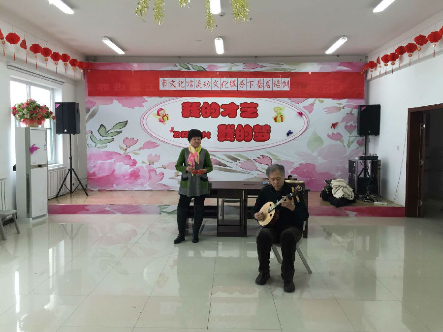 图为克拉玛依市流动特制文化服务讲解乐器